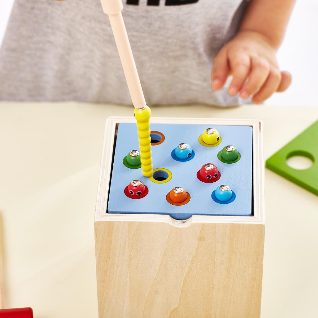 Steckspielzeug aus Holz mit Magnet Kind spielt
